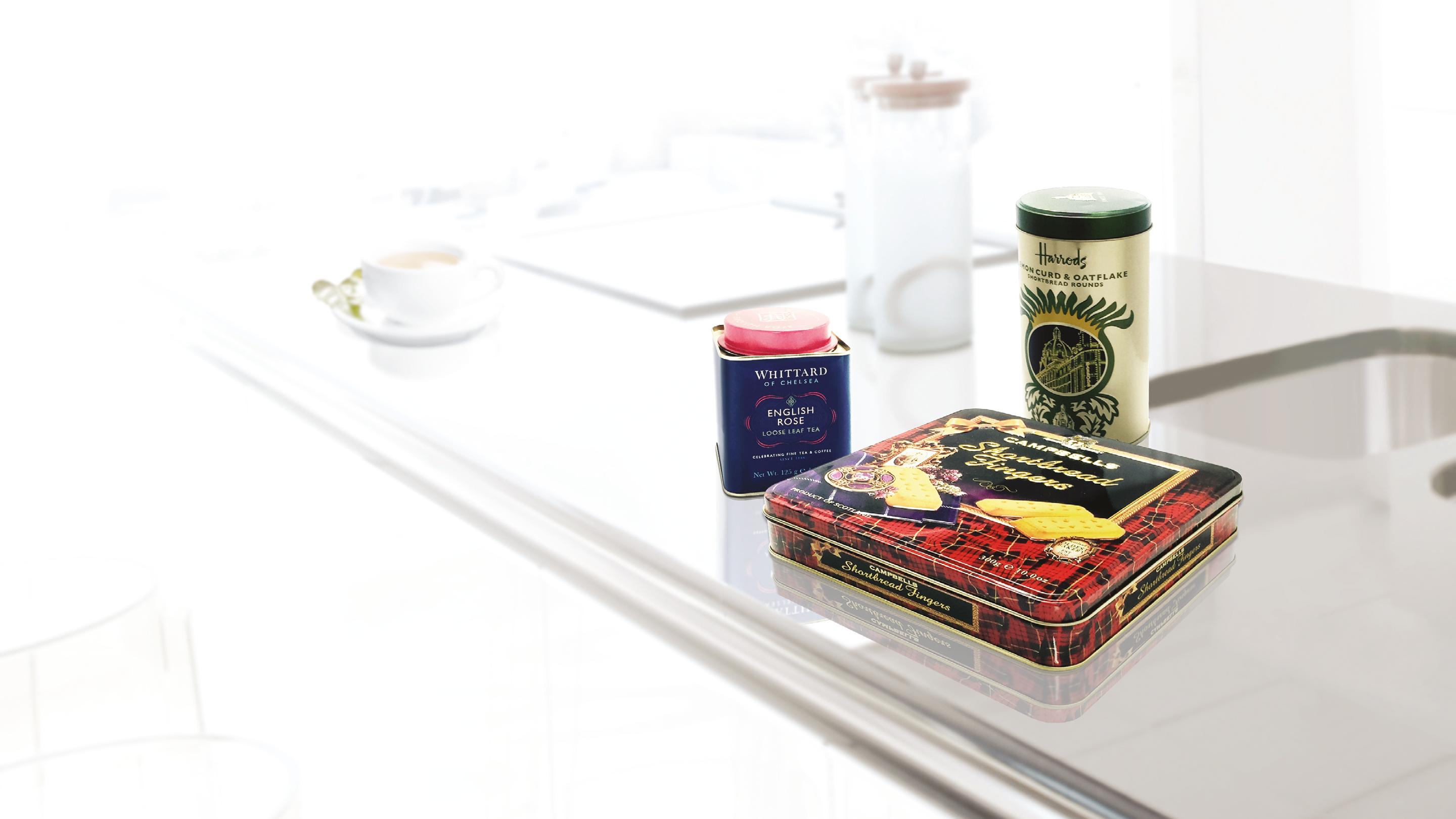 Biscuit tin on glass table with a white background.
