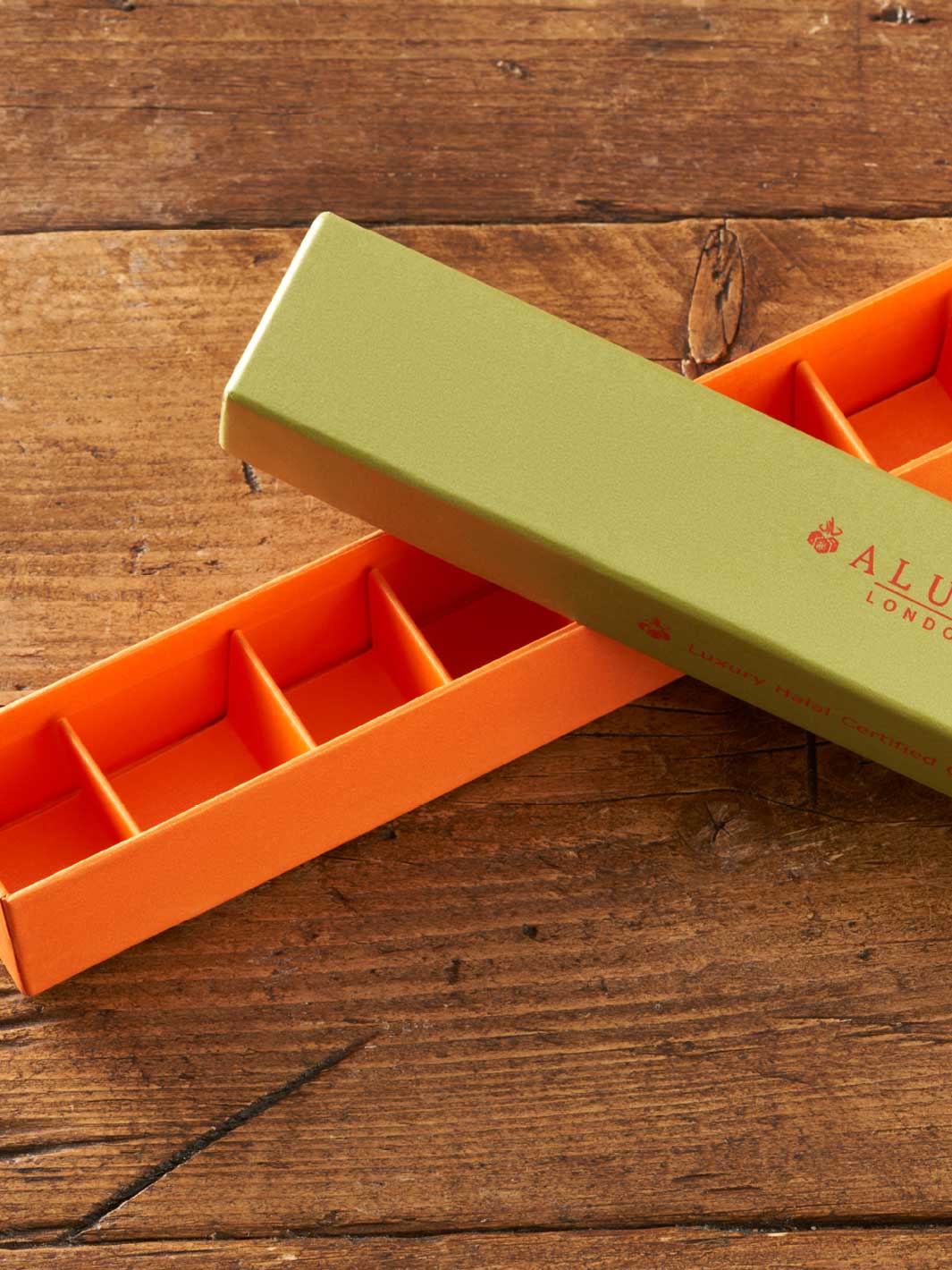 Fence divider cardboard box with a gold and orange design. 